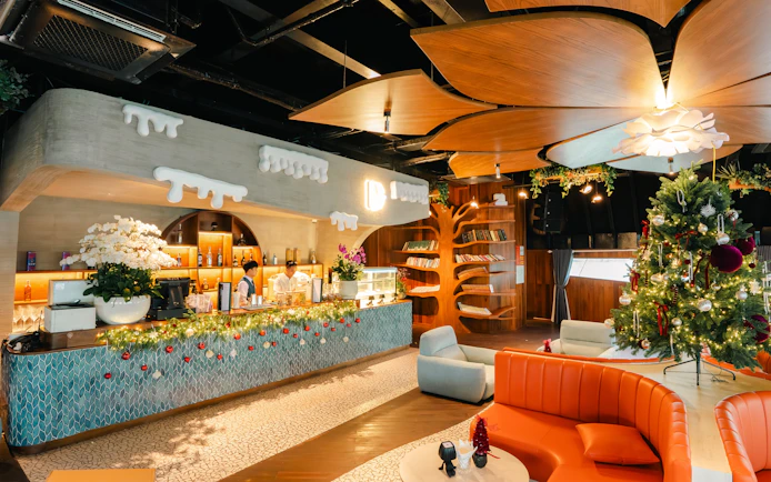 Lounge area of Dolphin cruise with festive decor, bar, and seating.