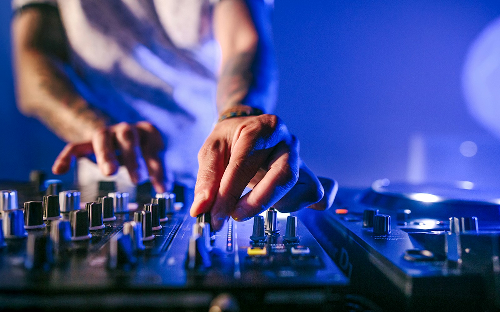 DJ performing on deck during Frankfurt evening panorama cruise with city skyline in background.