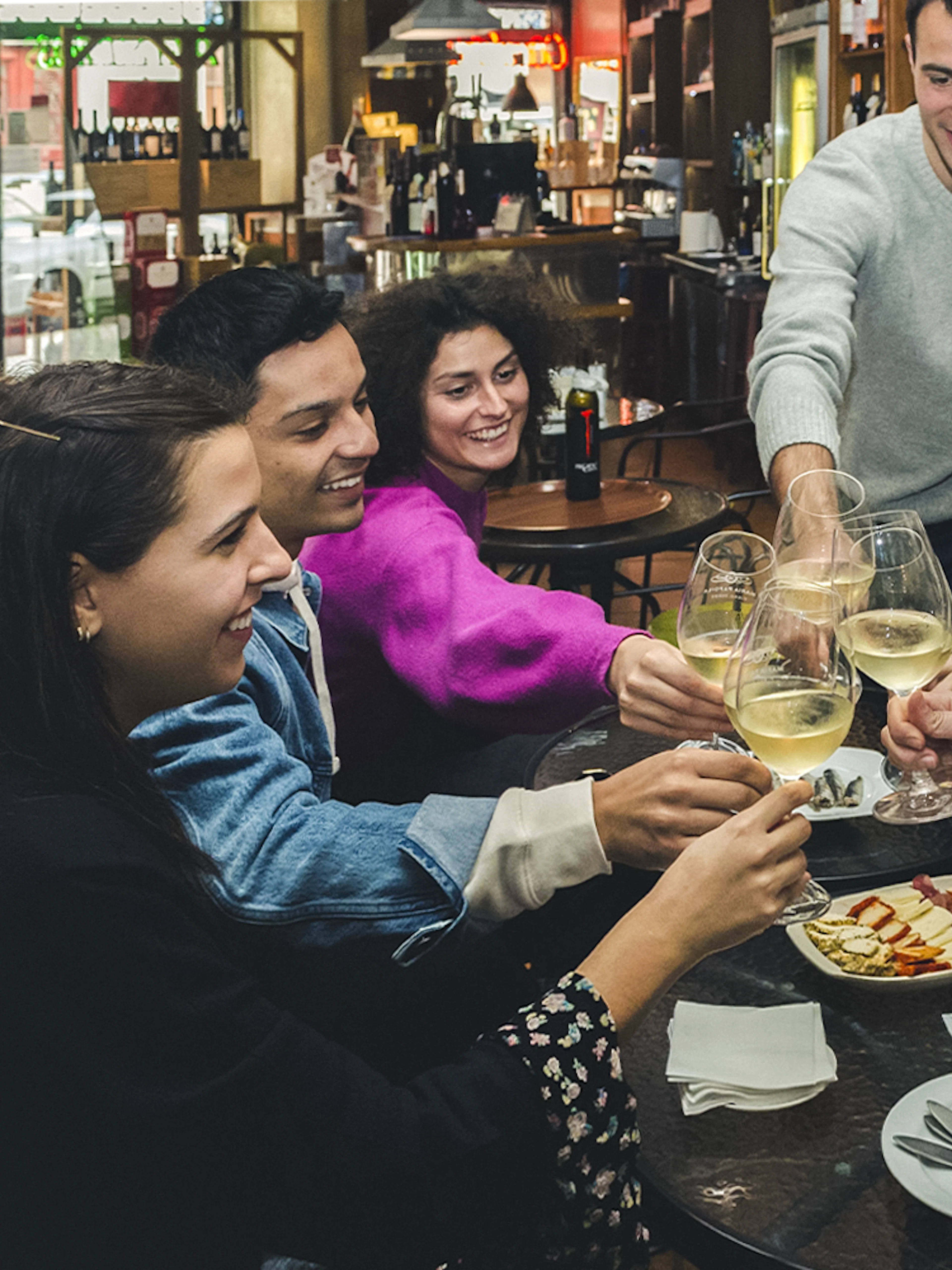 Group enjoying wine and petiscos at a bar during The Original Porto Petiscos Crawl.