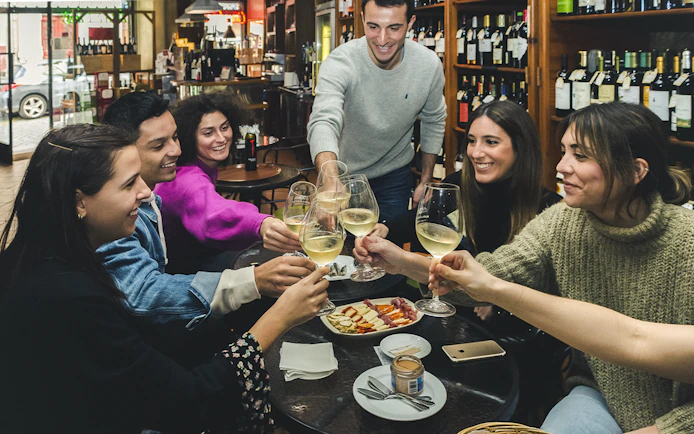 Group enjoying wine and petiscos at a bar during The Original Porto Petiscos Crawl.