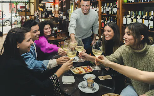 Group enjoying wine and petiscos at a bar during The Original Porto Petiscos Crawl.