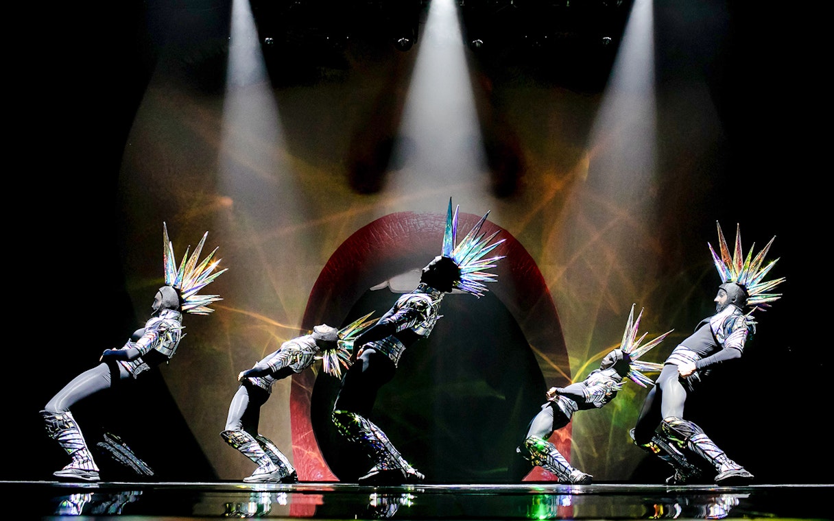 Performers in futuristic costumes with spiked headpieces at Paradis Latin show.