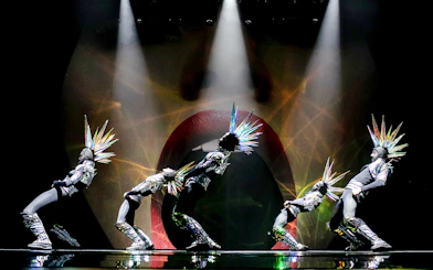 Performers in futuristic costumes with spiked headpieces at Paradis Latin show.