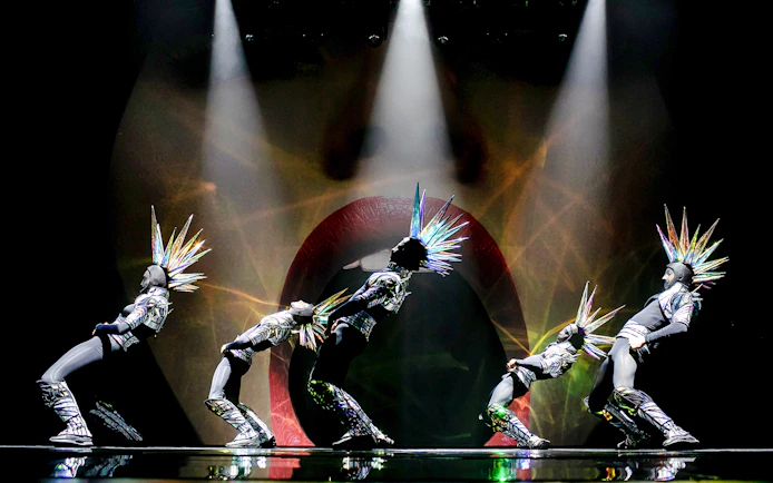 Performers in futuristic costumes with spiked headpieces at Paradis Latin show.