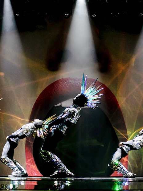 Performers in futuristic costumes with spiked headpieces at Paradis Latin show.