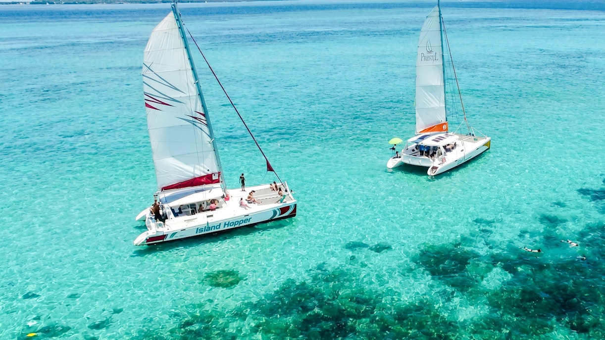 Catamarans sailing on turquoise waters near Ile aux Cerf, Mauritius.