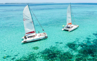 Catamarans sailing on turquoise waters near Ile aux Cerf, Mauritius.