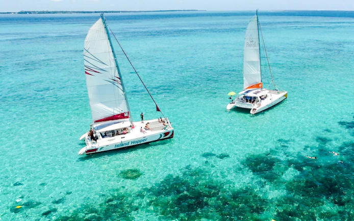 Catamarans sailing on turquoise waters near Ile aux Cerf, Mauritius.