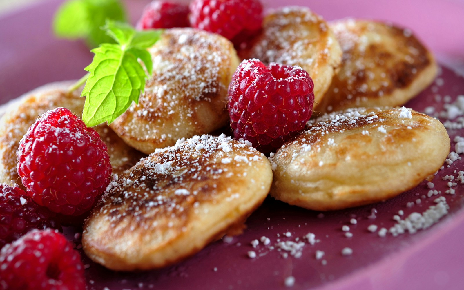 Dutch poffertjes being prepared on a griddle at an Amsterdam street market.