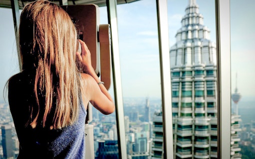 Person viewing Petronas Towers from observation deck, Kuala Lumpur.
