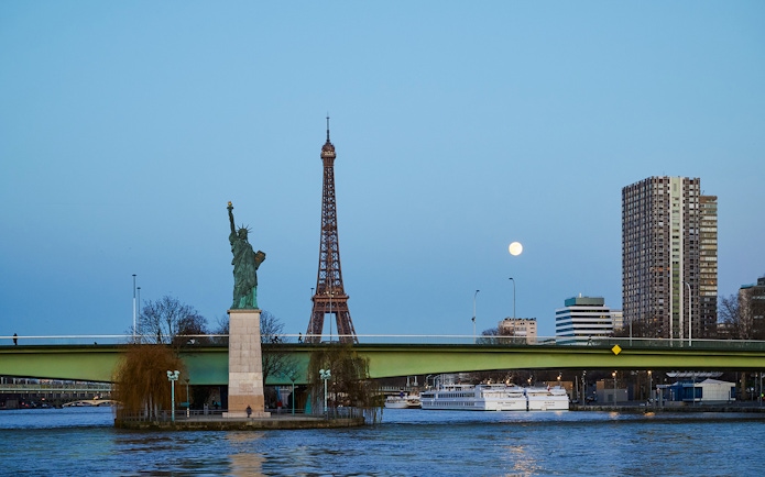 Eiffel Tower and Statue of Liberty from Seine River cruise in Paris.