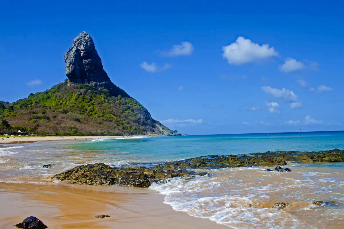 Fernando de Noronha coastline with Morro do Pico, clear waters, and sandy beach.