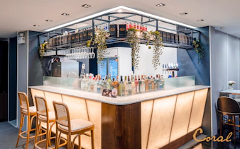 Bar area in Coral Finest Business Class Lounge, Concourse D1, Bangkok airport, featuring drinks and seating.
