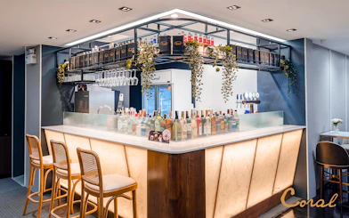 Bar area in Coral Finest Business Class Lounge, Concourse D1, Bangkok airport, featuring drinks and seating.