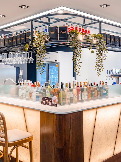 Bar area in Coral Finest Business Class Lounge, Concourse D1, Bangkok airport, featuring drinks and seating.