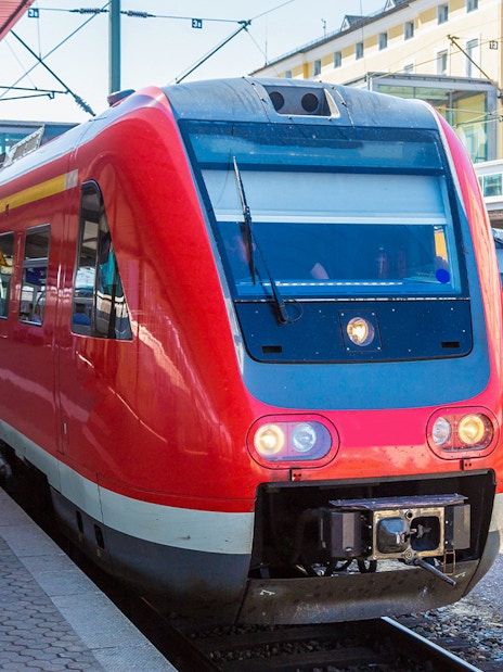 Red train at Munich station for Neuschwanstein Castle tour transfer.
