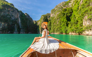 Woman in white dress on longtail boat, Maya Bay, Phi Phi Islands tour.