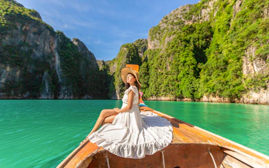 Woman in white dress on longtail boat, Maya Bay, Phi Phi Islands tour.