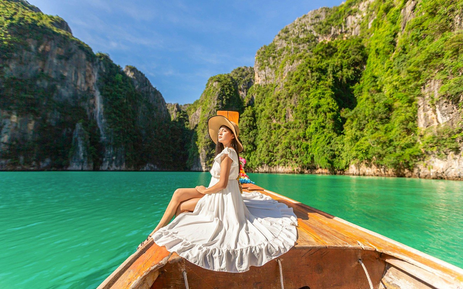 Woman in white dress on longtail boat approaching Maya Bay, Phi Phi Islands tour.