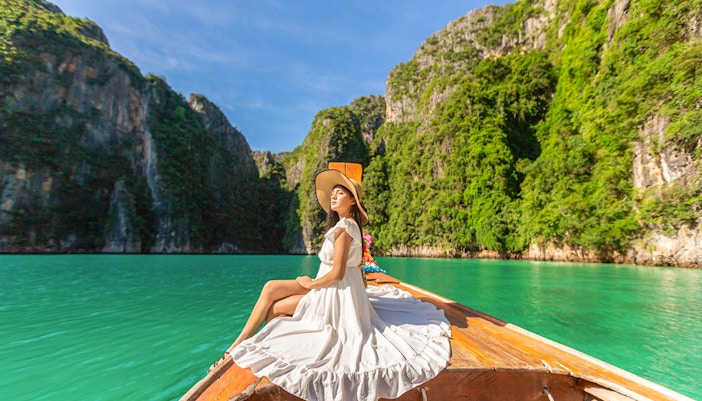 Woman in white dress on longtail boat, Maya Bay tour, Phi Phi Islands