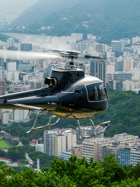 Helicopter taking off over Rio de Janeiro cityscape.