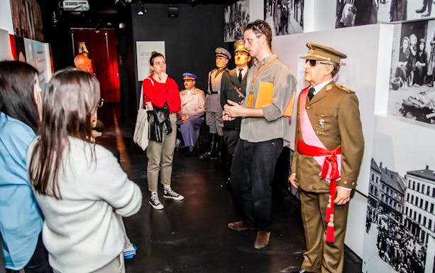 Visitors on a guided tour at Barcelona Wax Museum, viewing historical wax figures.