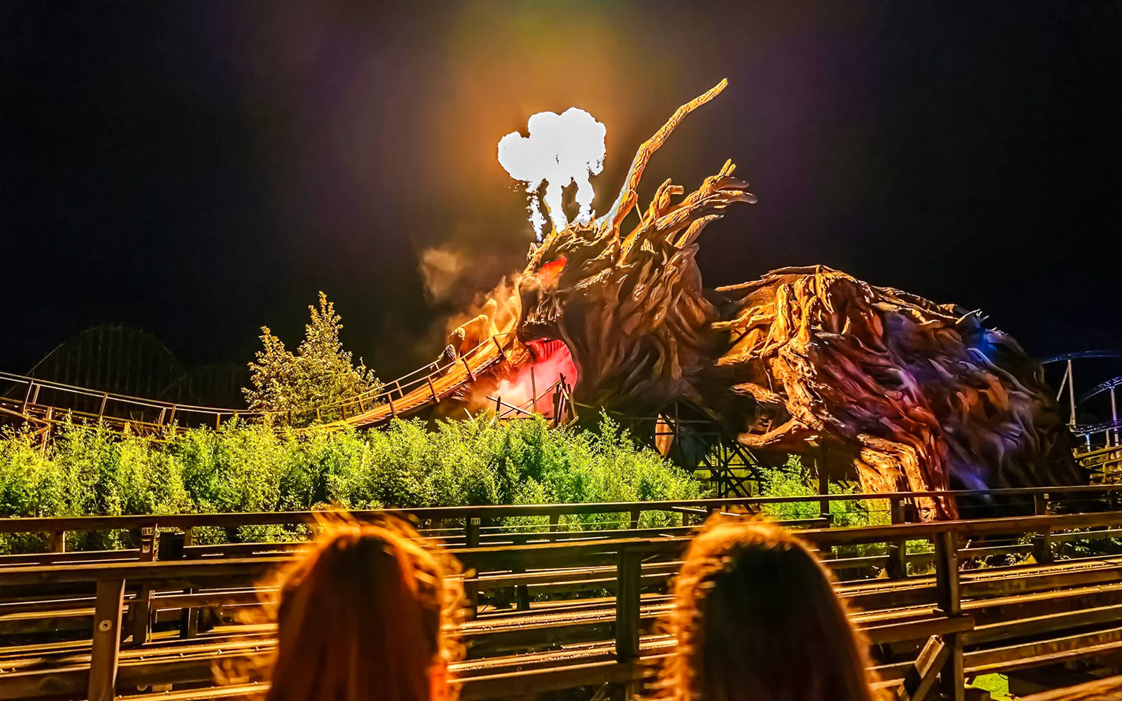 Roller coaster with dragon sculpture and fire effects at Heide Park Halloween event.
