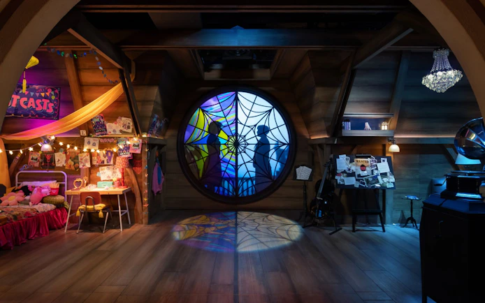 Stained glass window with silhouettes on the Wednesday play set, Netflix House, Philadelphia.