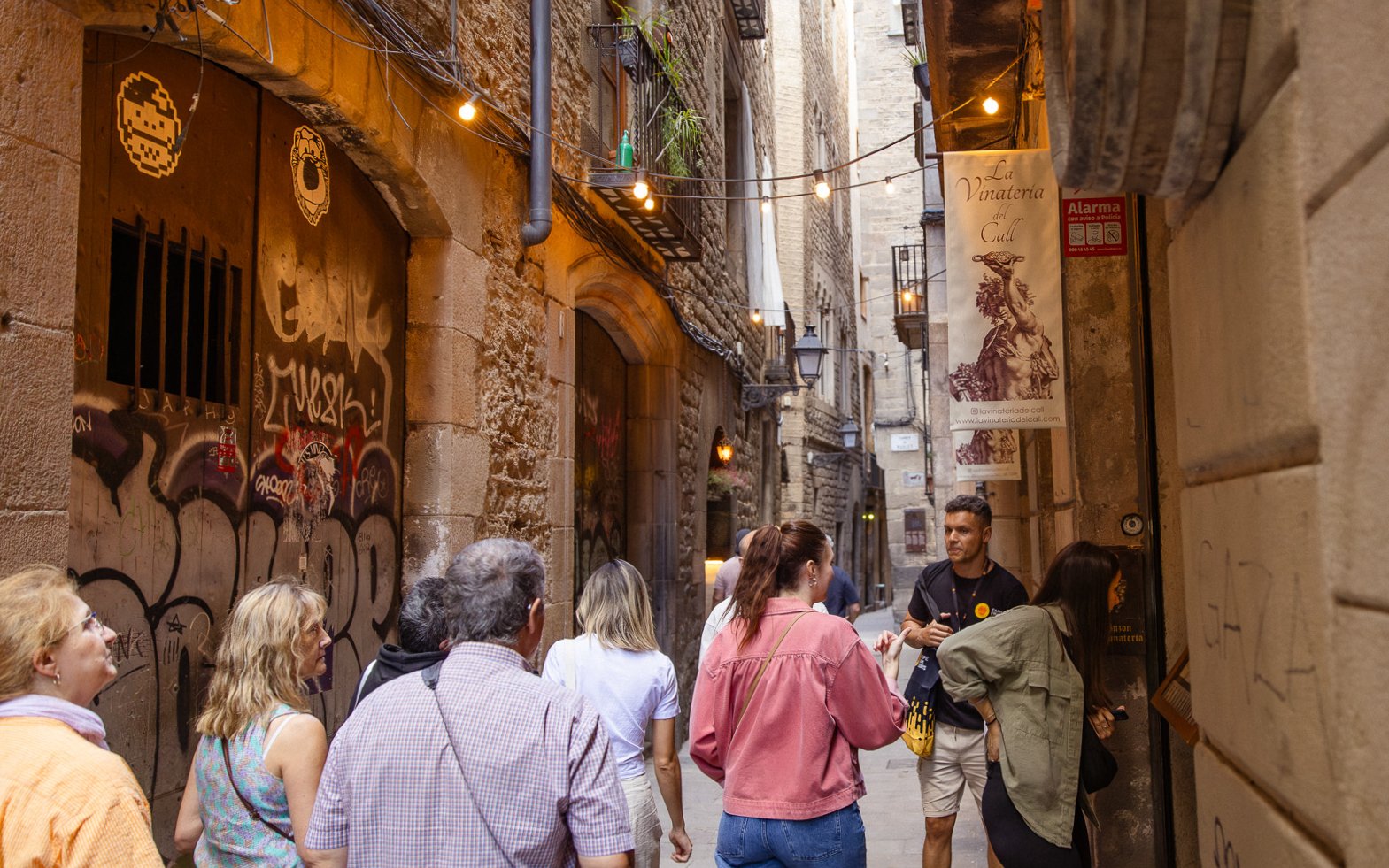 Tourists exploring a narrow street in Barcelona's Gothic Quarter.