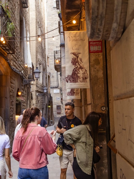 Tourists exploring a narrow street in Barcelona's Gothic Quarter.