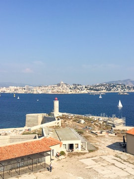 Château d’If with lighthouse and Marseille skyline in the background, France.