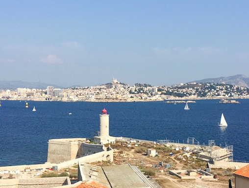 Château d’If with lighthouse and Marseille skyline in the background, France.