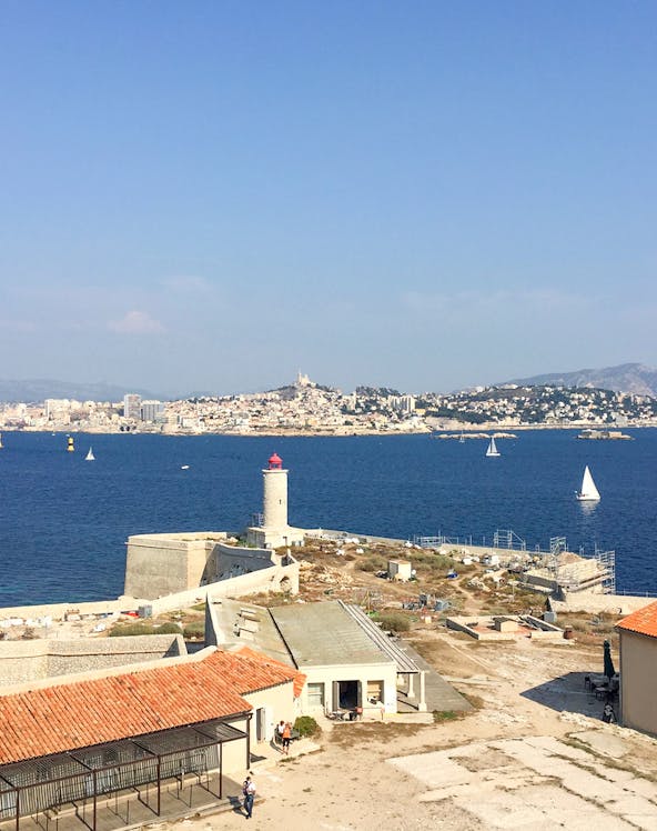 Château d’If with lighthouse and Marseille skyline in the background, France.