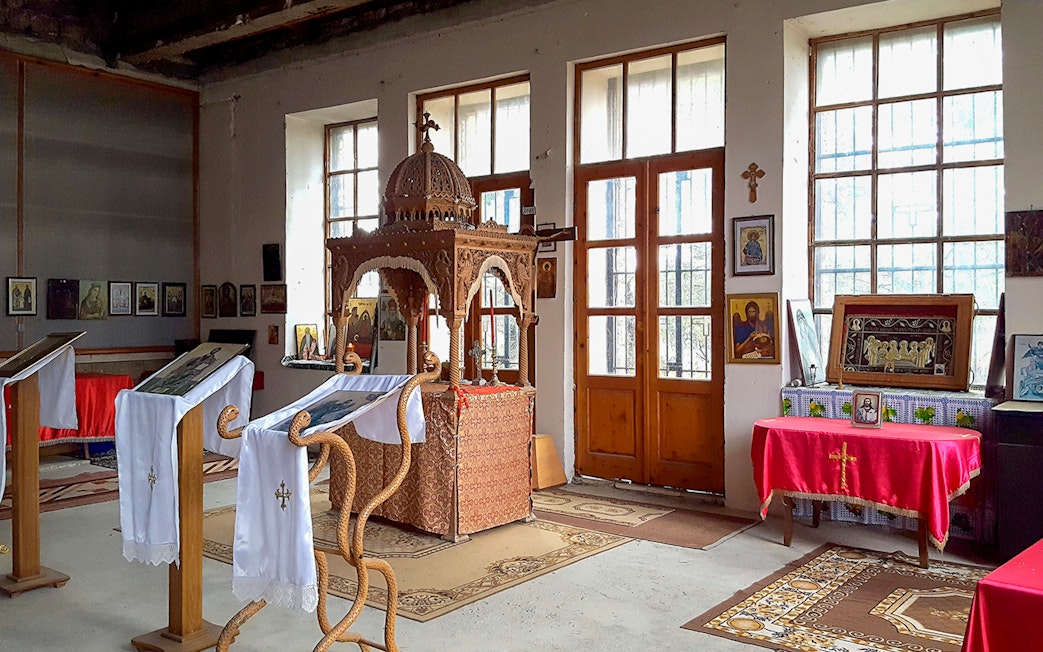 Interior of Berat Castle chapel with religious icons and wooden altar.