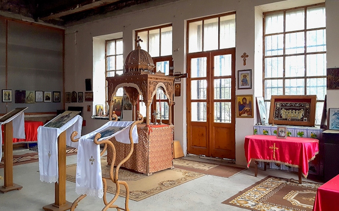 Interior of Berat Castle chapel with religious icons and wooden altar.