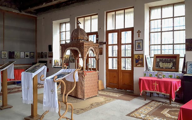 Interior of Berat Castle chapel with religious icons and wooden altar.