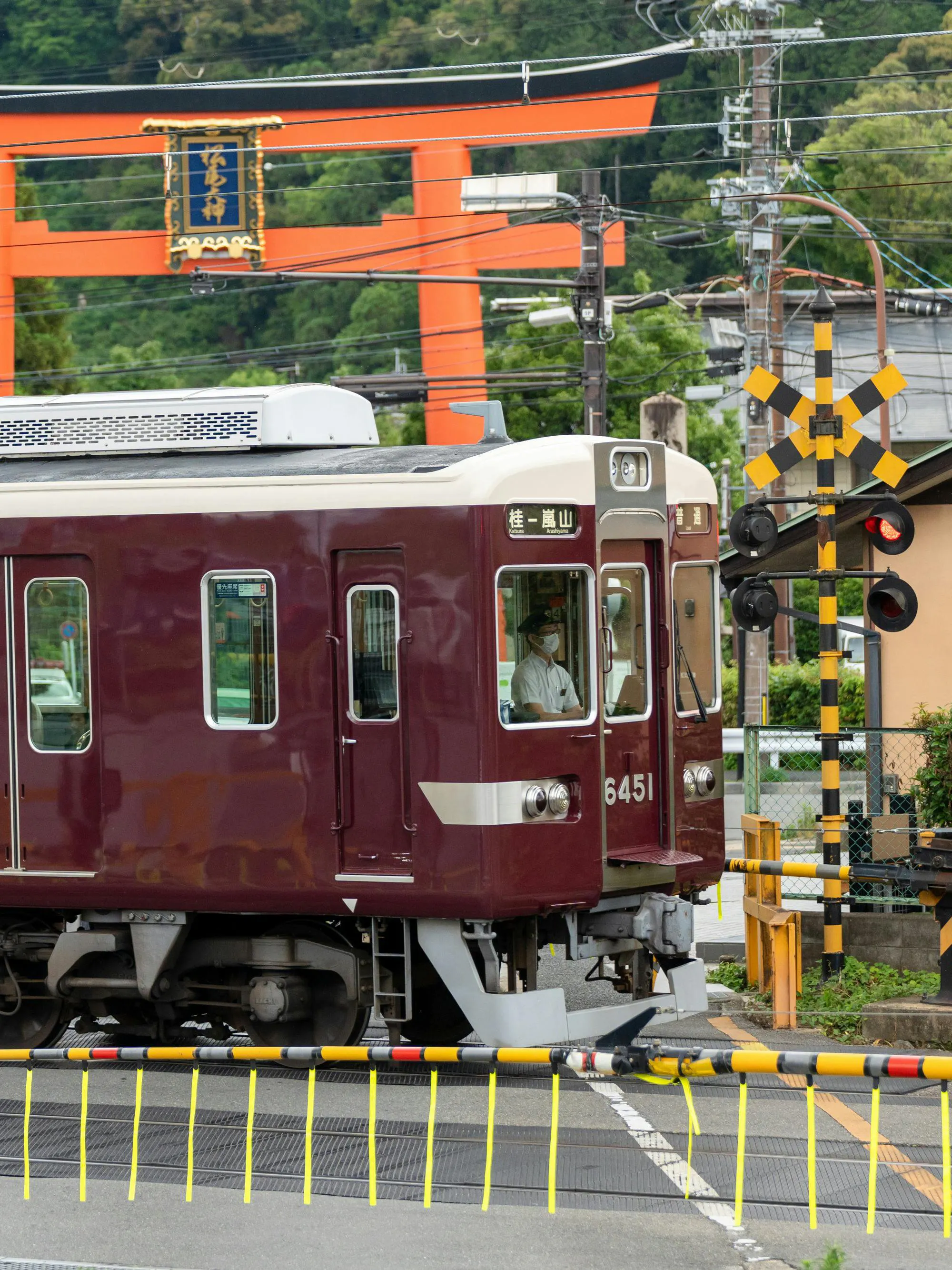 Train passing by a torii gate in Kyoto, Japan, on the Hankyu line.