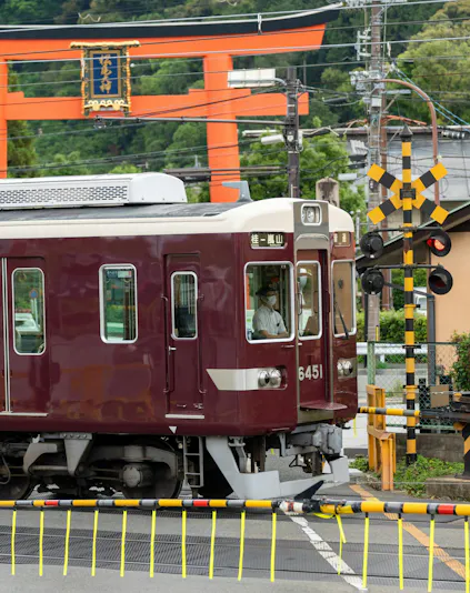 Train passing by a torii gate in Kyoto, Japan, on the Hankyu line.