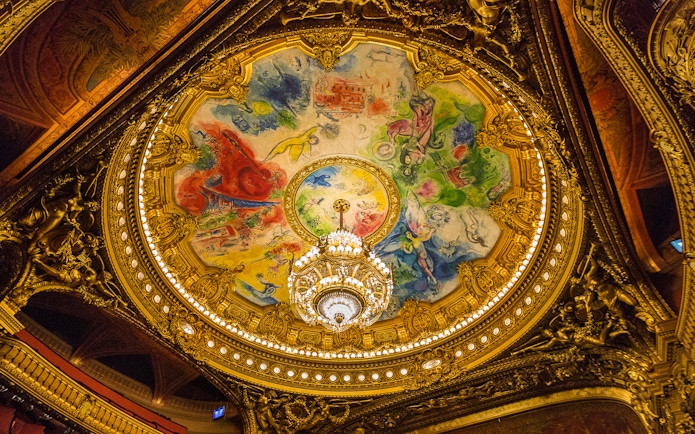 Ceiling of Opera Garnier in Paris with colorful fresco and ornate chandelier.