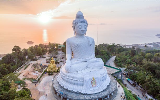 Big Buddha statue overlooking the sea at sunset in Phuket, Thailand.