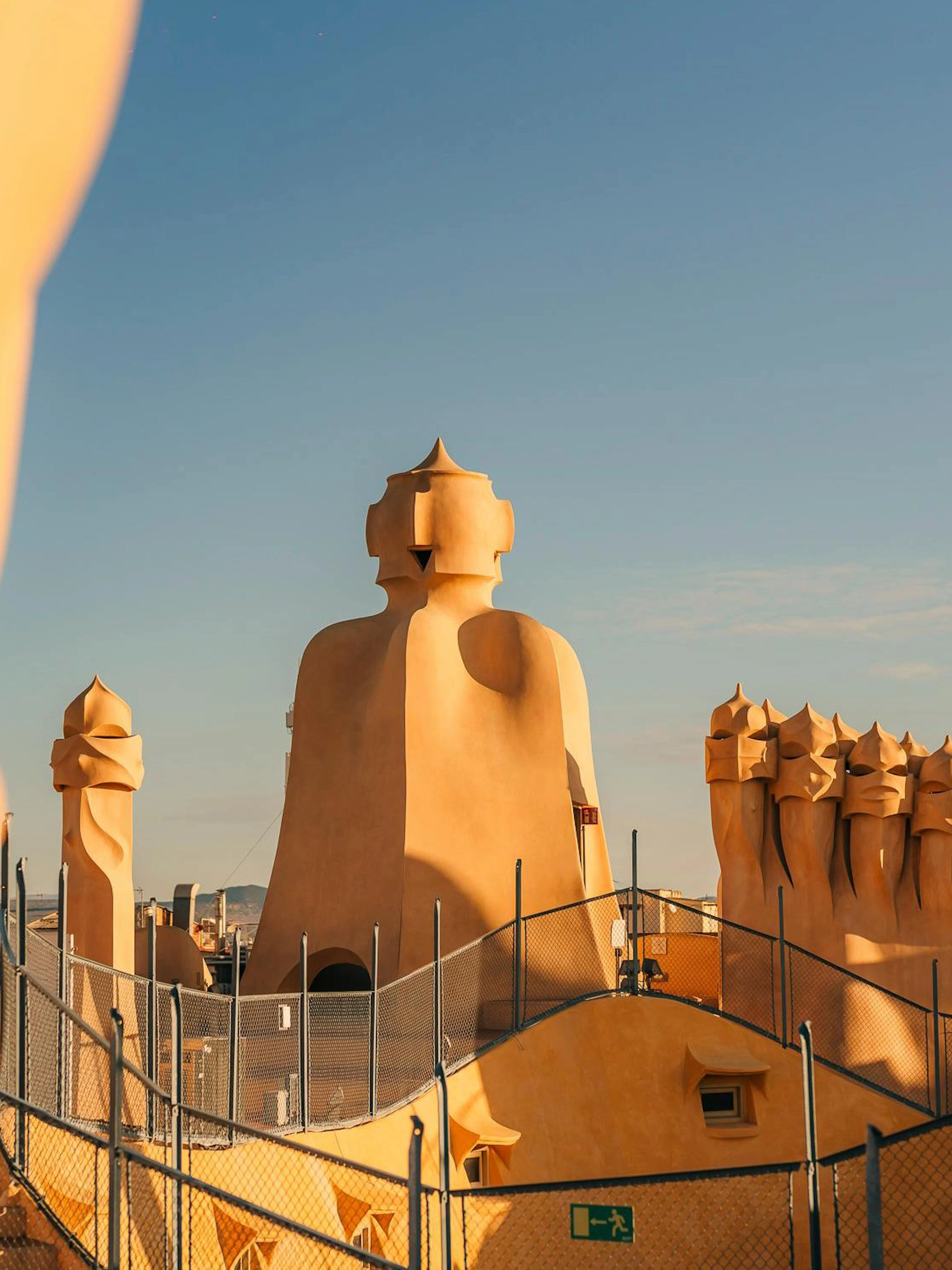 Rooftop chimneys of La Pedrera - Casa Milà during sunset in Barcelona.
