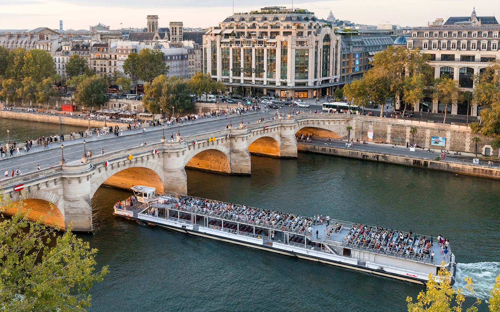 Seine River cruise boat with passengers enjoying live commentary in Paris.
