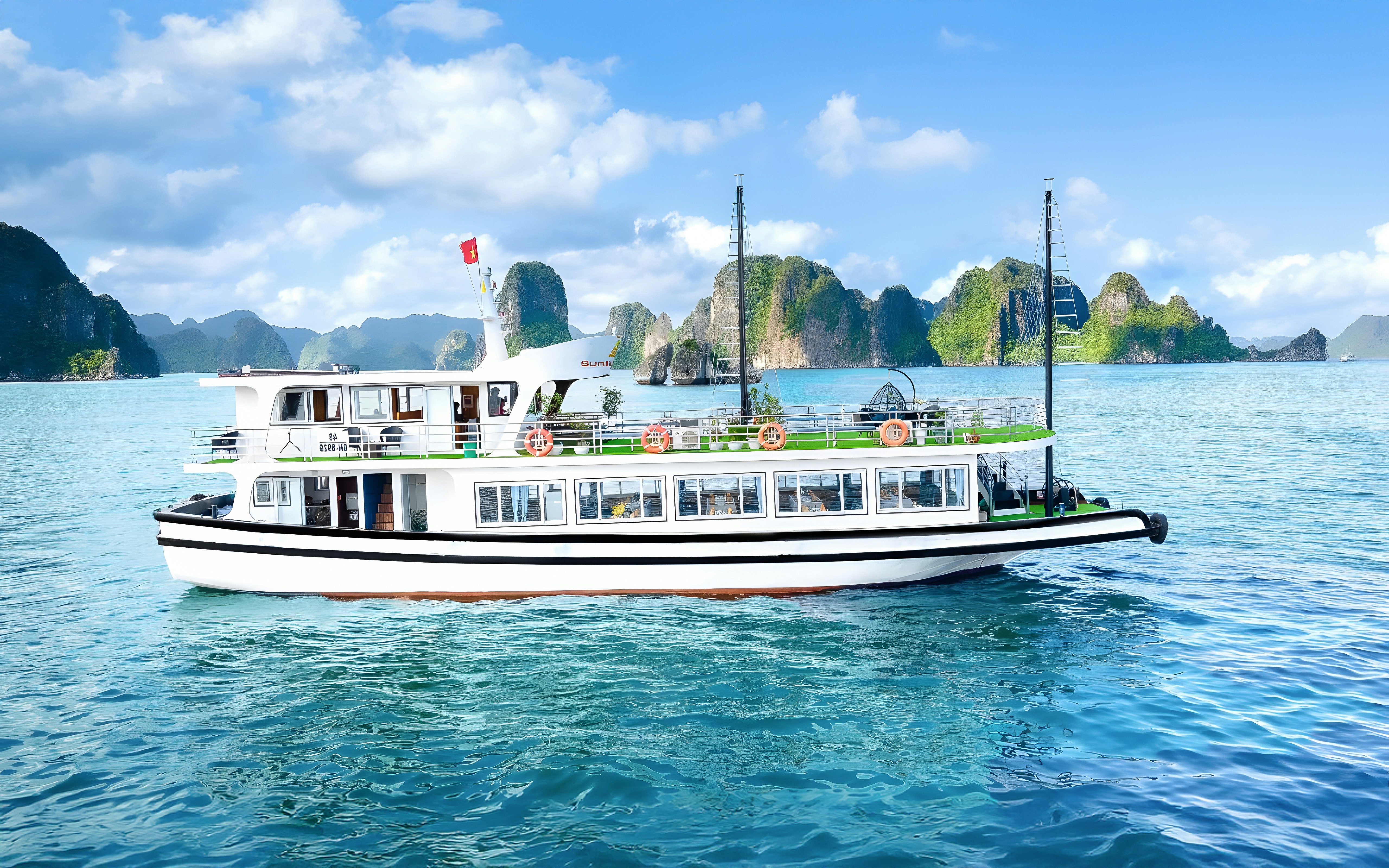 Ha Long Bay cruise ship passing limestone karsts, Vietnam.