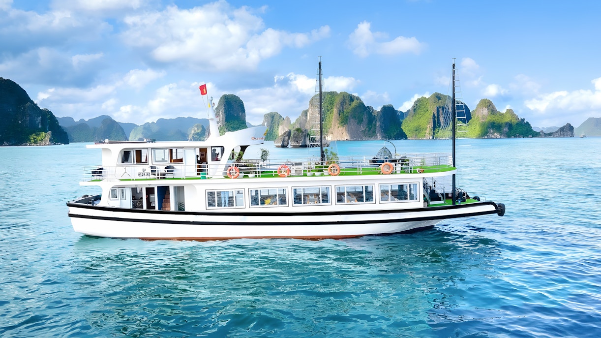 Ha Long Bay cruise ship passing limestone karsts, Vietnam.