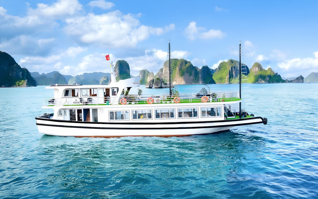 Ha Long Bay cruise ship passing limestone karsts, Vietnam.