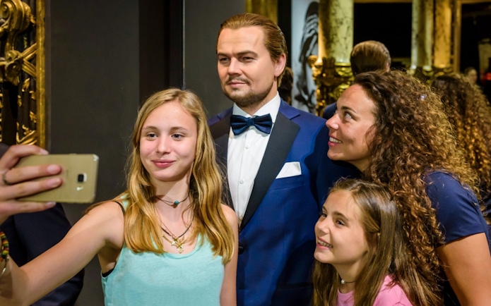 Visitors taking a selfie with a wax figure at Grévin Paris Wax Museum.