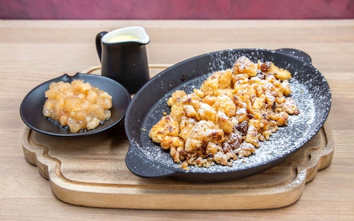 Hungarian dessert Kaiserschmarrn with apple compote and vanilla sauce in Budapest.