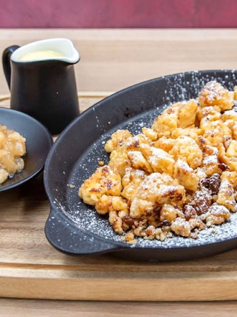 Hungarian dessert Kaiserschmarrn with apple compote and vanilla sauce in Budapest.