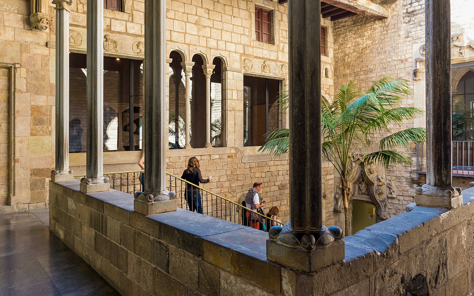 Tourists with guide exploring courtyard of Picasso Museum in Barcelona.