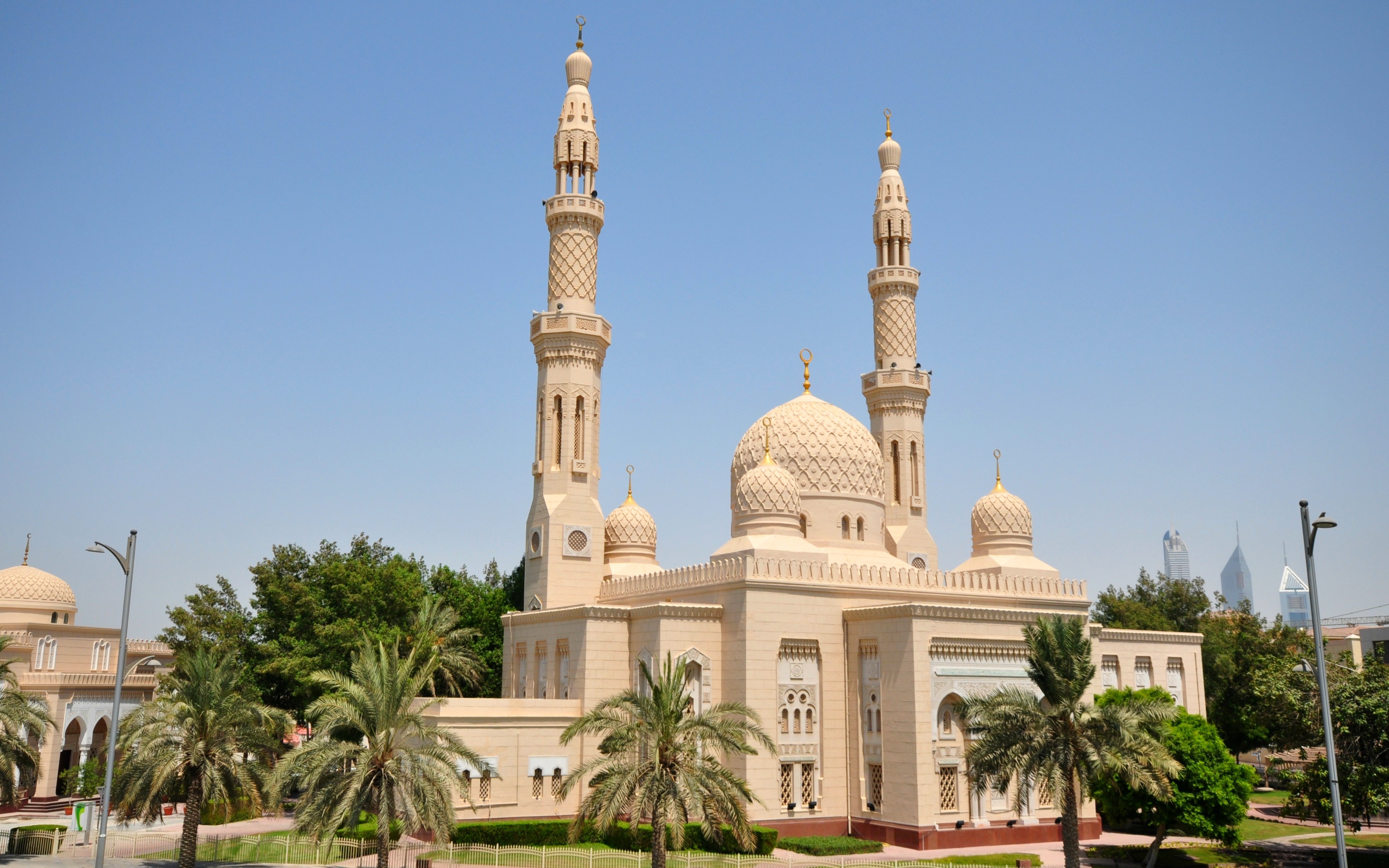 Jumeirah Mosque with twin minarets and palm trees in Dubai.